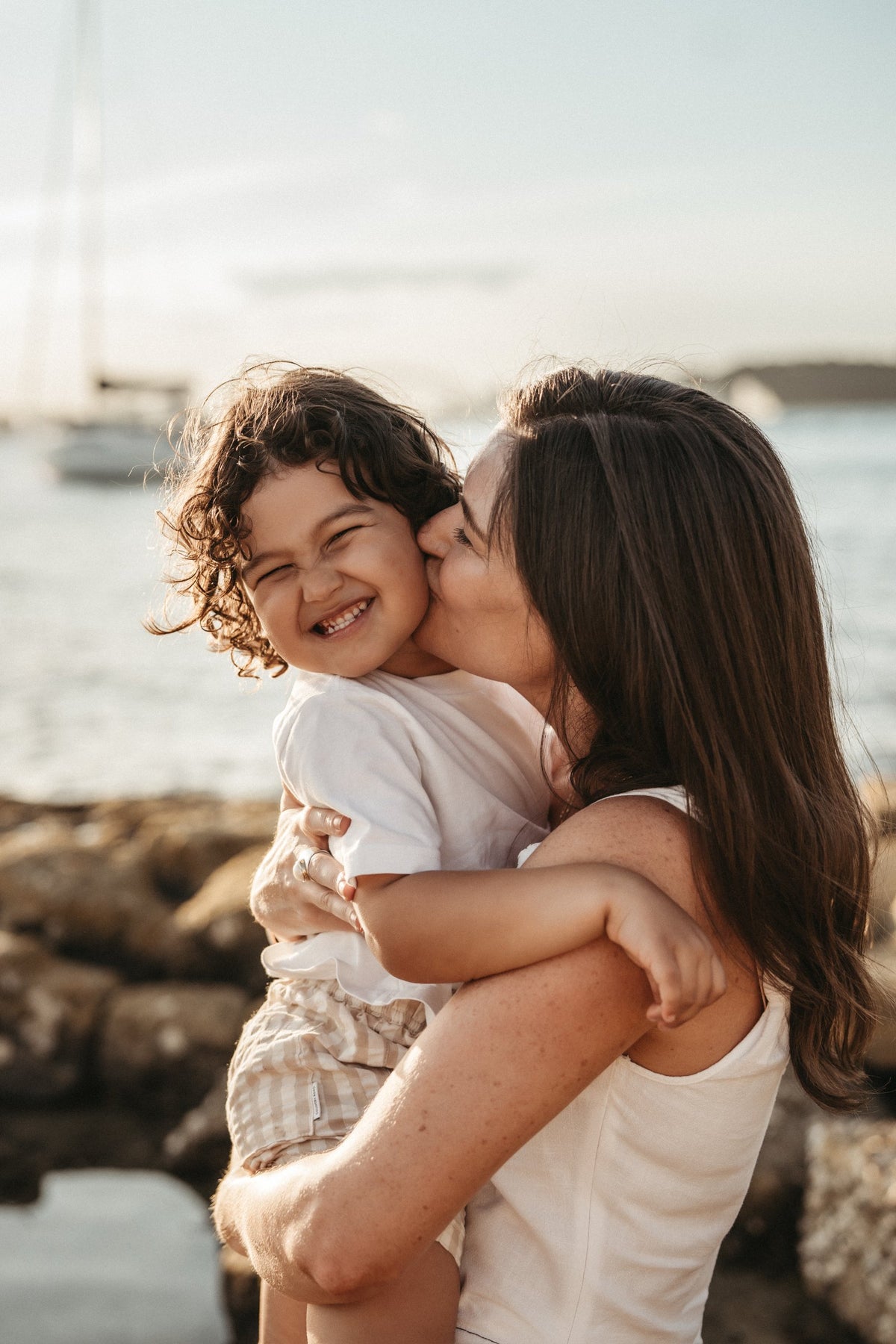 Beach family shoot: mum kissing son