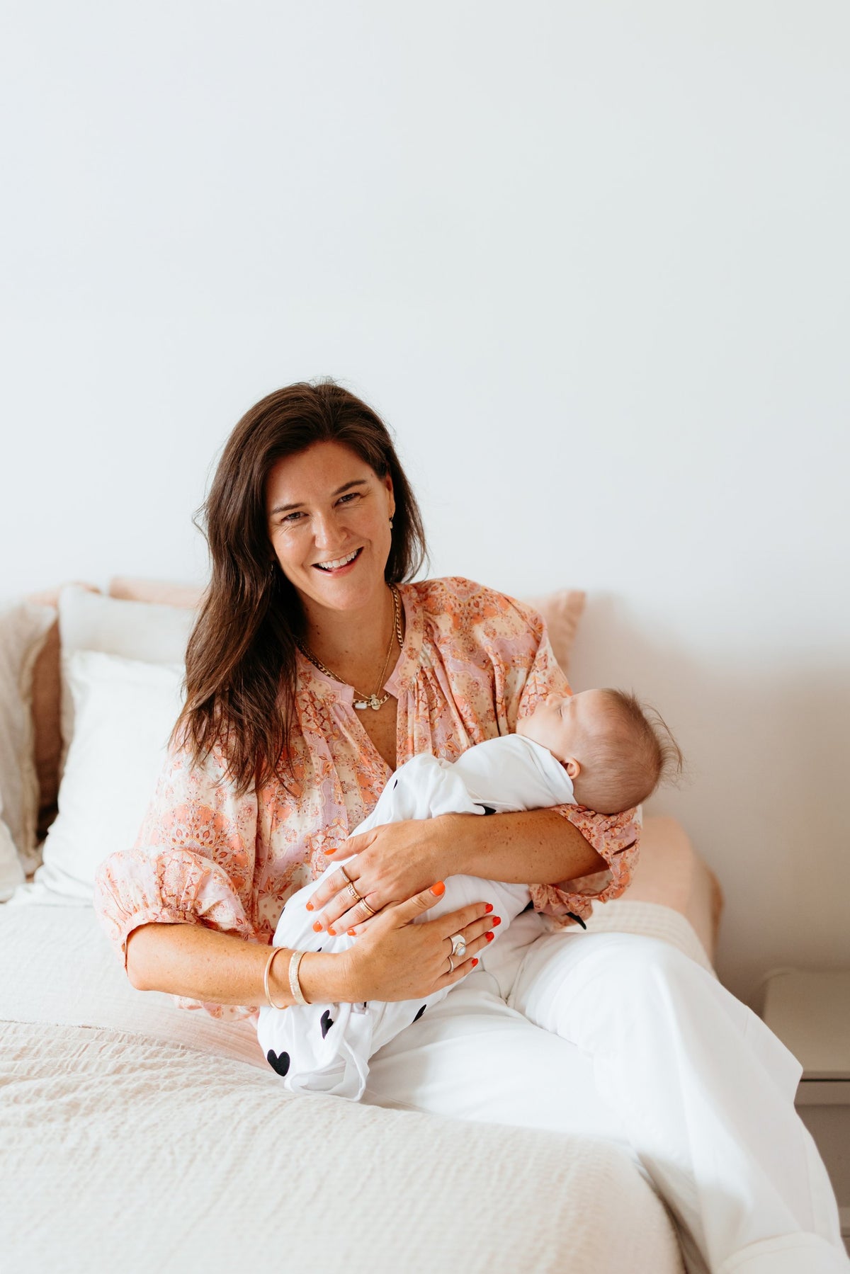 In-home consult shoot: mum smiling with newborn